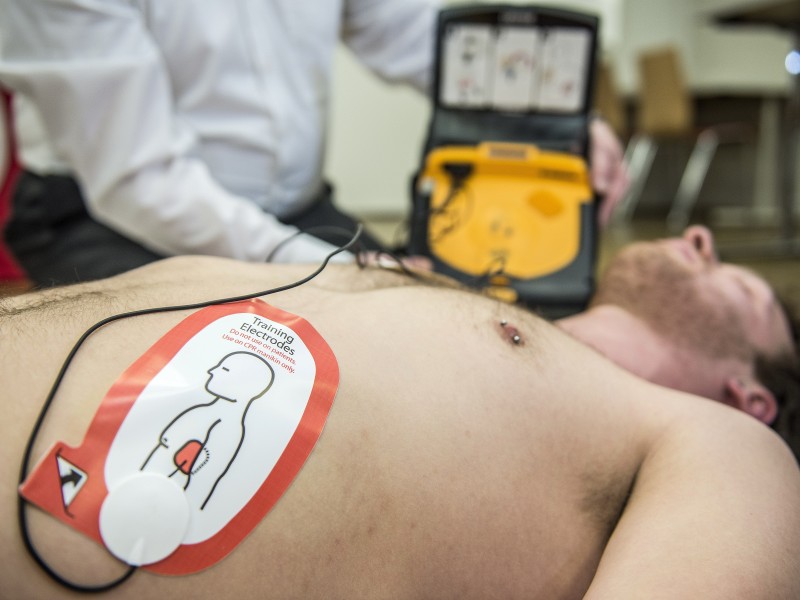 Ist die Bewusstlosigkeit festgestellt, klappt man den Defibrillator (AED) auf, der einen anleitet. Zunächst setzt man den Notruf ab und klebt die Elektroden auf.