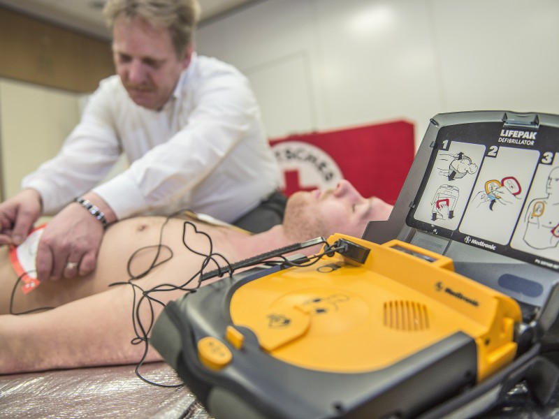 Ist die Bewusstlosigkeit festgestellt, klappt man den Defibrillator (AED) auf, der einen anleitet. Zunächst setzt man den Notruf ab und klebt die Elektroden auf.