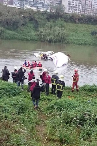 Die Retter versuchen mit Schlauchbooten an das Flugzeug im Fluss zu kommen.