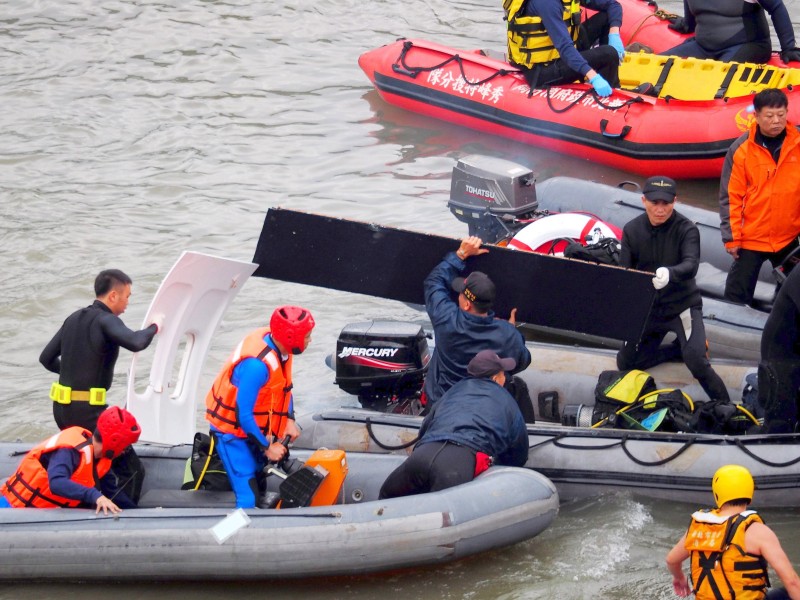 Die Helfer finden Wrackteile im Fluss und heben sie in ihre Schlauchboote.