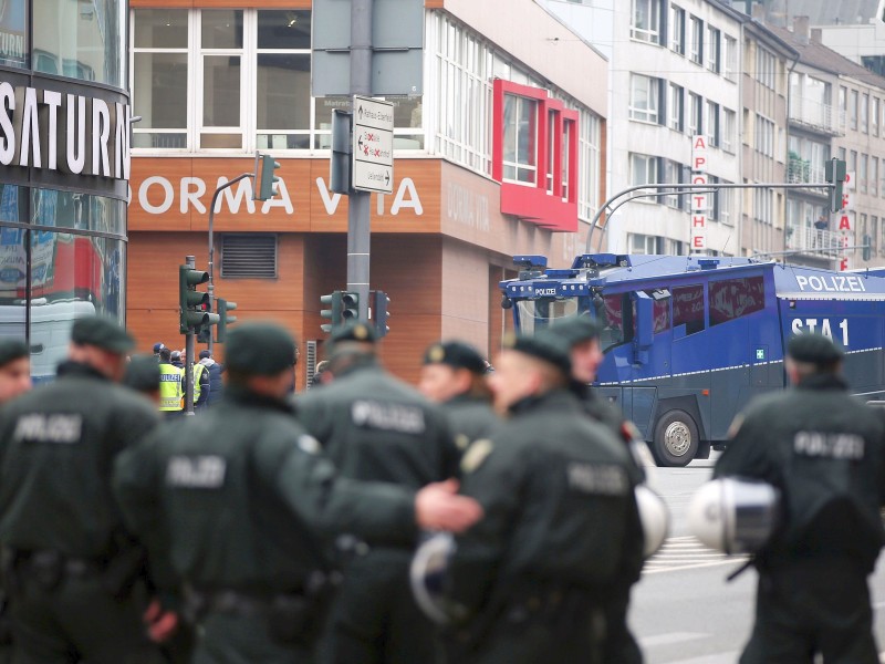 Polizisten und Wasserwerfer stehen in der Stadt.