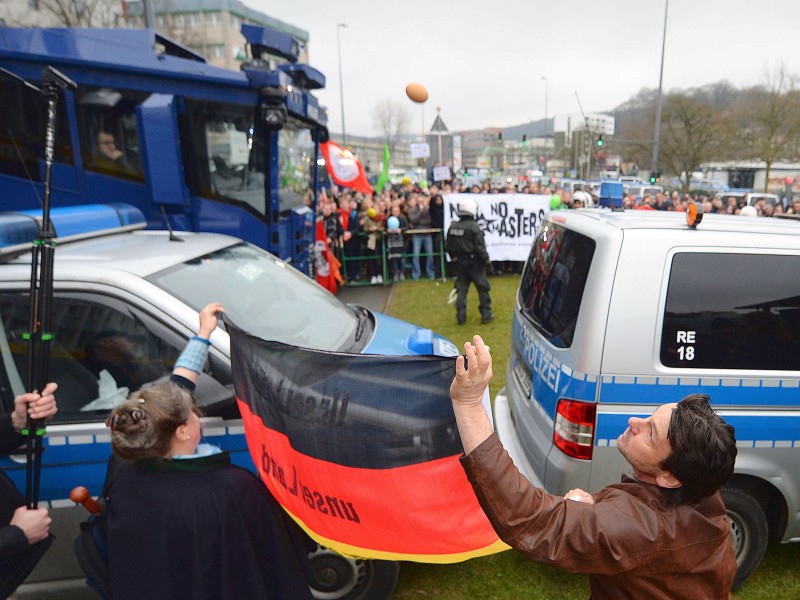 Anhänger der Pegida  werden von Gegendemonstranten mit Eiern beworfen.