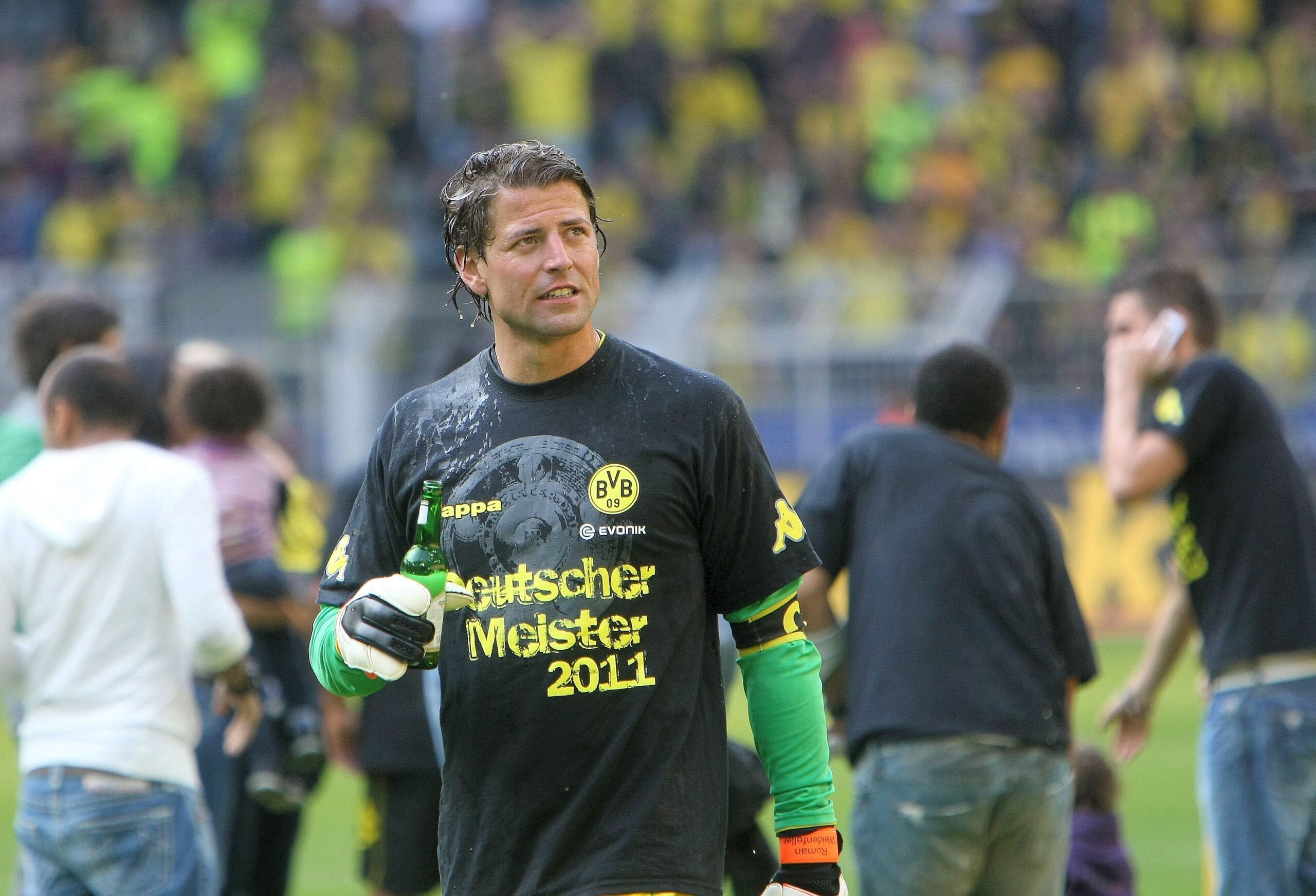 Beim Meistersieg 2011 war es wohl kühl – BVB-Keeper Roman Weidenfeller hält sein Nach-Bierduschen-Bier mit seinen Torwarthandschuhen fest.