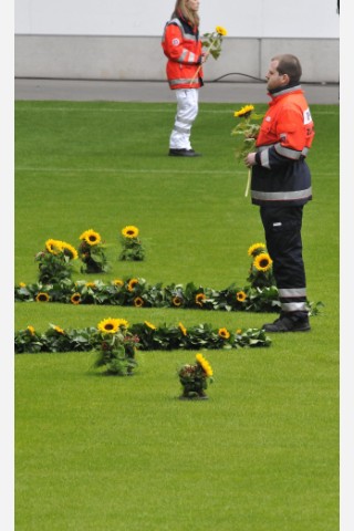 Helfer der Rettungsdienste legten in der MSV-Arena für jedes Todesopfer eine Sonneblume nieder. Foto: Kai Kitschenberg/WAZFotoPool