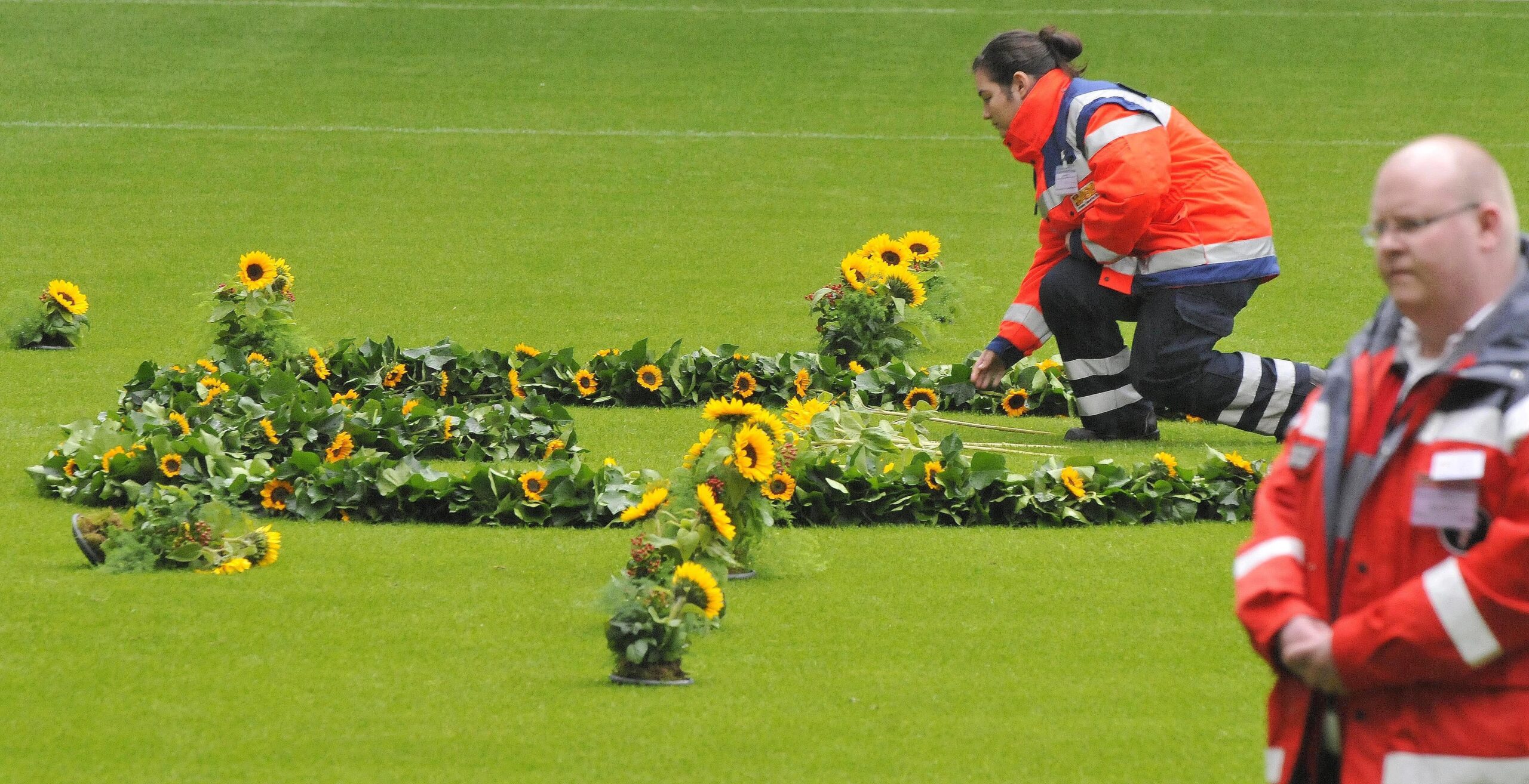 Helfer der Rettungsdienste legten in der MSV-Arena für jedes Todesopfer eine Sonneblume nieder. Foto: Kai Kitschenberg/WAZFotoPool