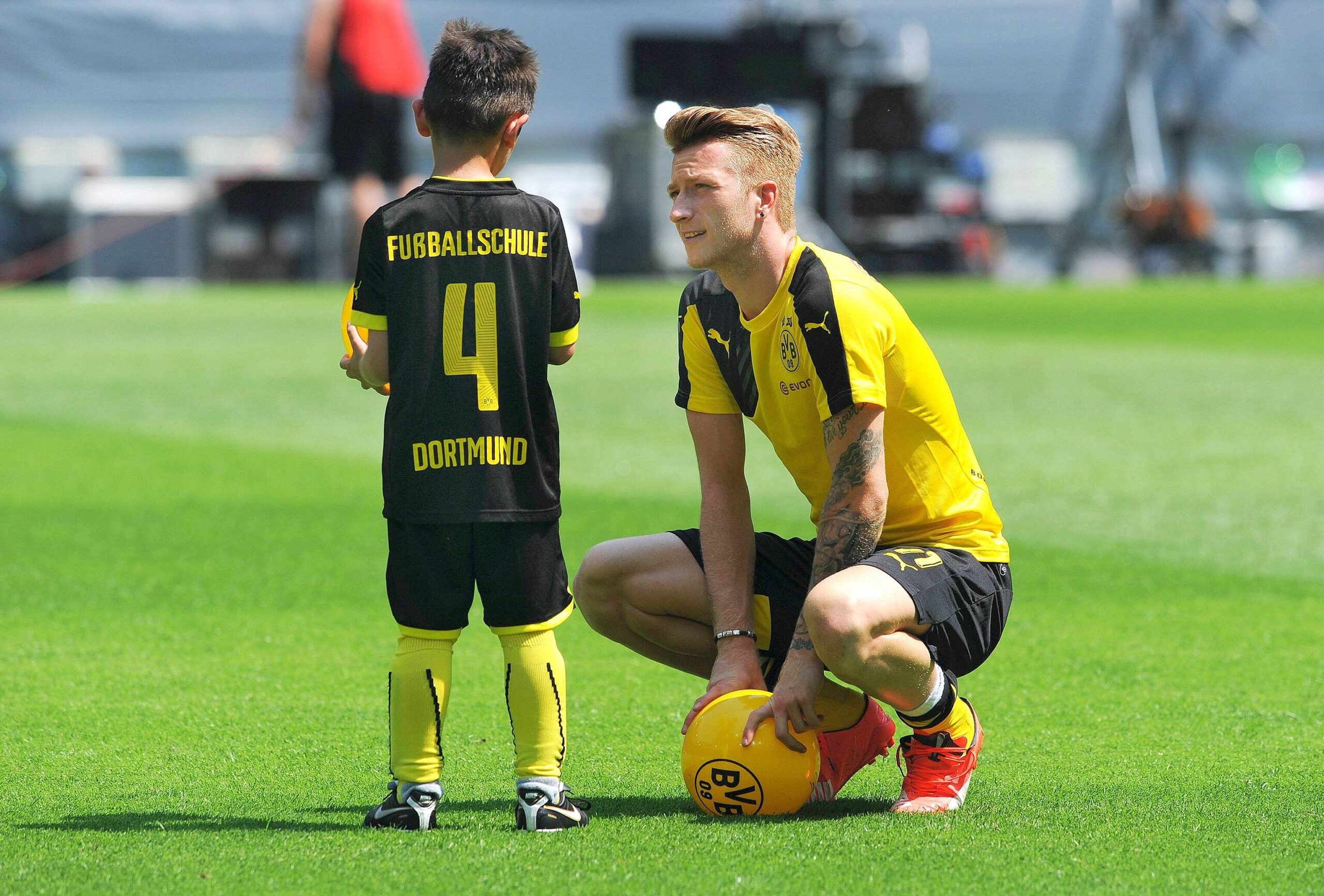 Fussball-Bundesliga, Deutschland, Herren, Saison 2015/2016, Saisoneröffnung im Signal Iduna Park, Bor. Dortmund, BVB - Team Gold; Marco Reus (BVB) unterhält sich mit einem kleinen Jungen aus der Fussballschule Dortmund.Football Bundesliga Germany men Season 2015 2016 Season opening in Signal Iduna Park Bor Dortmund Borussia team Gold Marco Reus Borussia maintains to with a small Boys out the Football school Dortmund