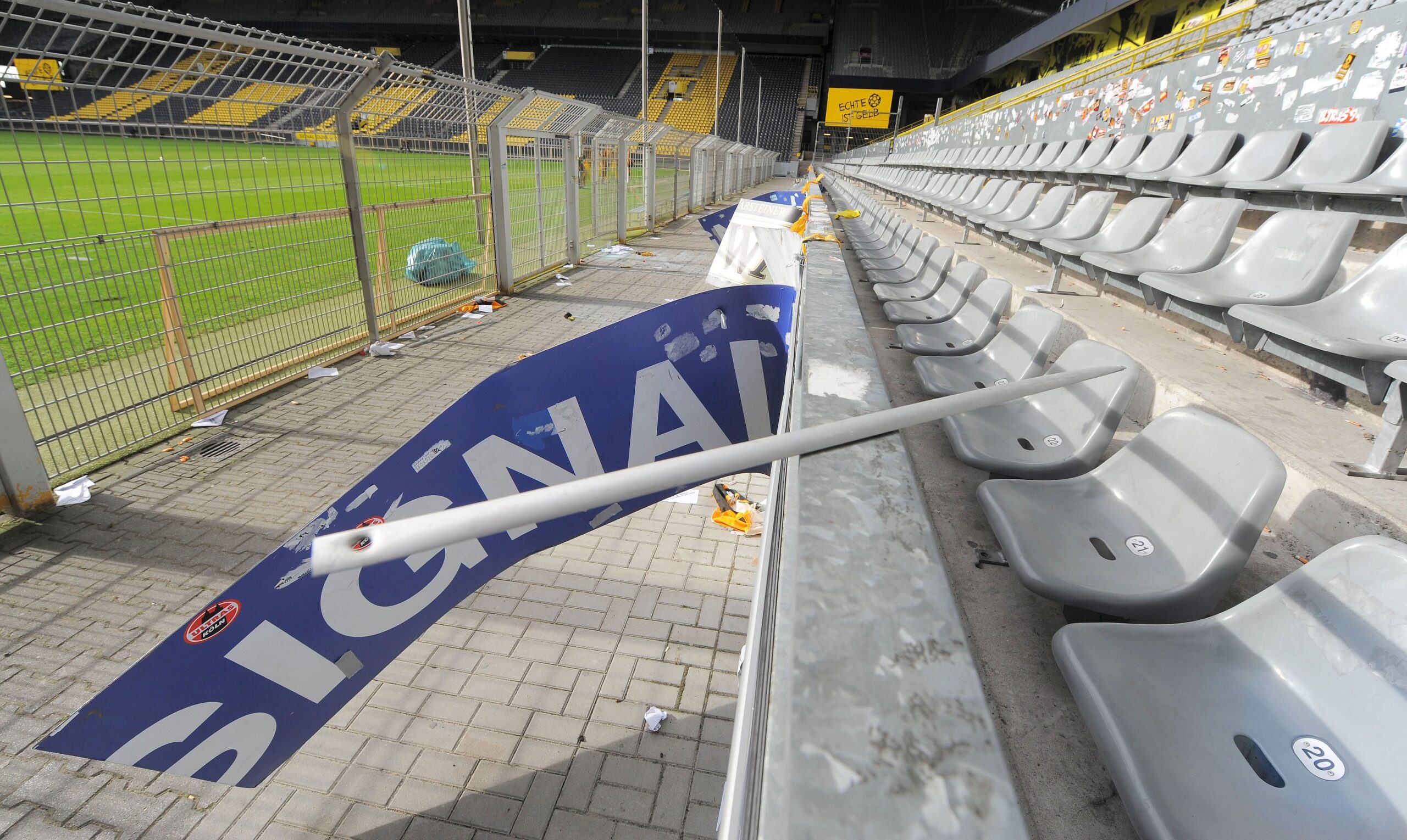 Am Tag nach dem Pokalspiel zwischen Borussia Dortmund und Dynamo Dresden zeigen sich die Schäden am Gästeblock: zerstörte Werbebanden, angekokelte Fahnen und Reste von Pyrotechnik.