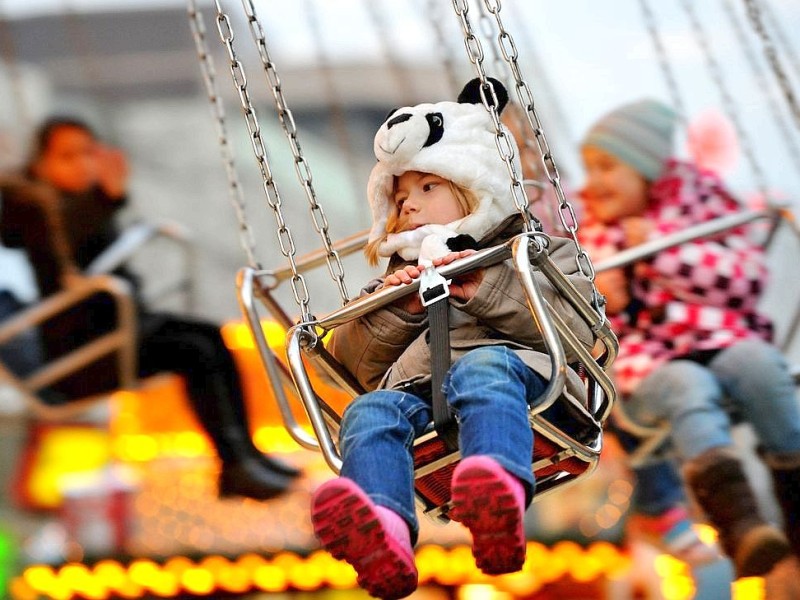 Am Donnerstag, den 17.11.2011 wird der Weihnachtsmarkt in der Innenstadt in Duisburg eröffnet. Bei kaltem trockenen Wetter kommen tausende Besucher, um den ersten glühwein zu trinken oder leckere heiße Maronen zu essen.  Im Foto: die 4- jährige Nele auf dem Kettenkarusell Foto: Stephan Eickershoff / WAZ FotoPool