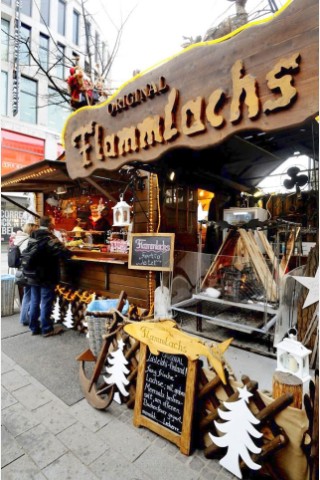 Am Freitag, den 18.11.2011 steht Mario Traber an seinem Stand auf dem Weihnachtsmarkt in Duisburg - Mitte. Dort verkauft er zum ersten Mal seinen Flammlachs . Der frische Lachs aus Finnland wird dabei über einem Holzfeuer nach alter finnischer Tradition gegart Foto: Stephan Eickershoff / WAZ FotoPool