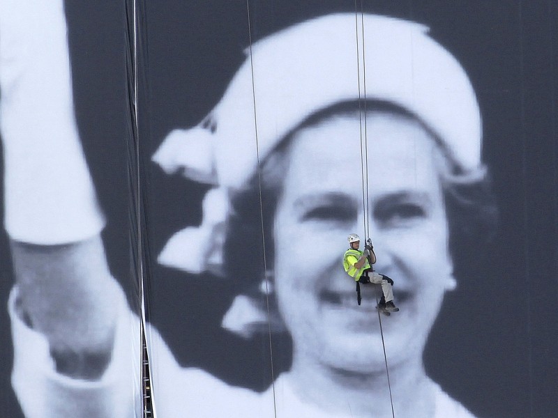 Zum diamantenen Jubiläum sichert ein Fassadenkletterer ein gigantisches Porträt der Queen. Das Portrait selbst stammt vom Silbernen Jubiläum 1977.