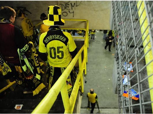 Dortmunder Fans gehen eine Treppe im Block 13 der Südtribüne hinab, über deren Geländer vor Spielbeginn ein BVB-Fan gestürzt war. Der Mann starb im Krankenhaus an den Folgen des Sturzes. Foto: ddp