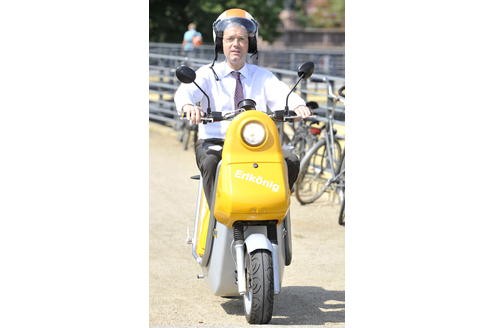 Unter dem Motto Für mich. Für dich. Fürs Klima wirbt Bundesumweltminister Norbert Röttgen im Juni 2010 für Elektromobilität. Hier sieht man ihn in Berlin auf einem Elektro-Motorroller.