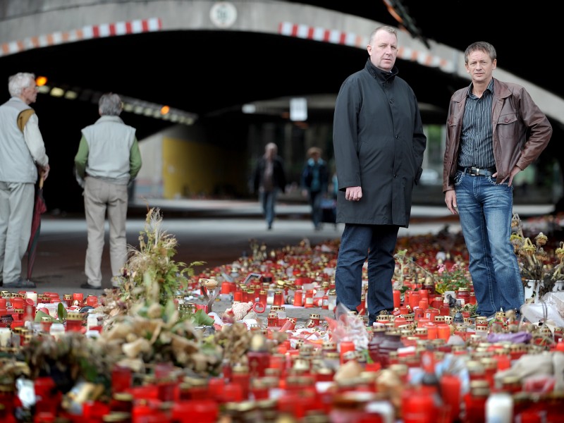 Arno Eich, Polizist in Duisburg, Geschäftsführer des Kulturzentrums Steinhof, Mitinitiator der „Initiative Spendentrauermarsch“, engagiert sich im „Bürgerkreis Gedenken“ (hier rechts im Bild mit Mitstreiter Karl Janssen, Kulturdezernent). Auf Bitten der Angehörigen der Todesopfer übernahm die Staatskanzlei unter Hannelore Kraft die Planungen für die Gedenkfeier am ersten Jahrestag. Die Staatskanzlei übertrug die Leitung Arno Eich. In einer Erklärung hielt er fest, wie er von der Stadt Duisburg in der Folge gegängelt wurde: ...