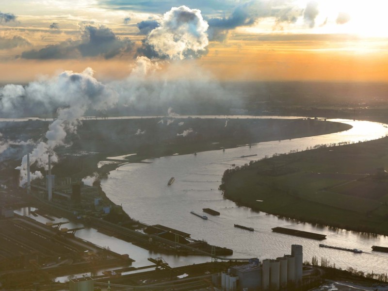 Der Rheinbogen bei Beeckerwerth mit dem Hafen Schwelgern von Thyssen-Krupp Stahl im Sonnenuntergang. Der Rhein führt Hochwasser.