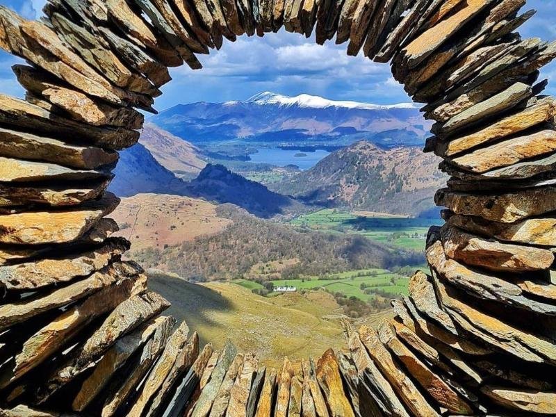 Durch ein kreisförmiges Steinkunstwerk ist das Borrowdale-Tal im Lake District zu sehen. Es stammt von einem Unbekannten.