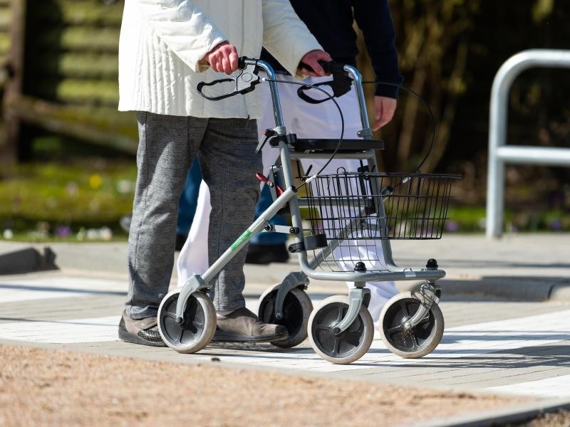 Eine Physiotherapeutin erklärt einer Seniorin den Umgang mit dem Rollator auf einem Parcour.