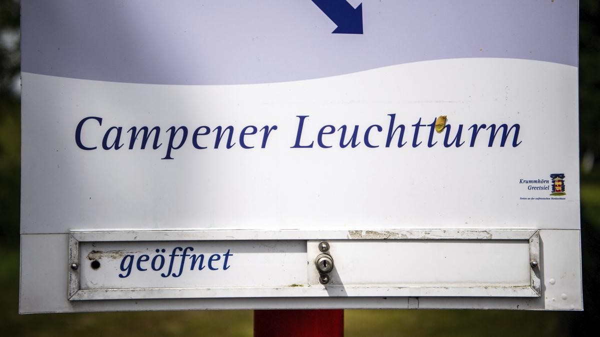  "Geöffnet" steht an einem Schild, das auf den Campener Leuchtturm hinweist. Deutschlands höchster Leuchtturm in Campen in Ostfriesland ist nach fast einem Jahr Generalüberholung wieder für Besucherinnen und Besucher geöffnet.