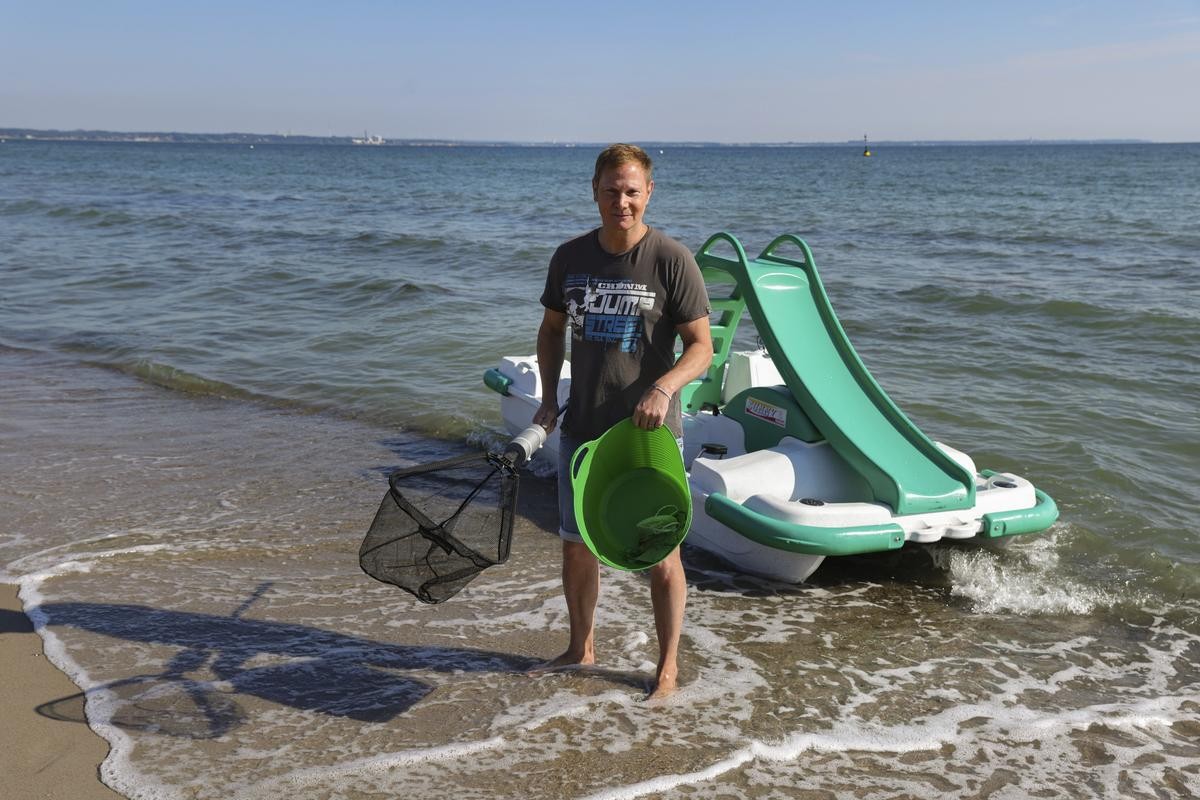 Schauspieler und Projektpate Fabian Harloff steht mit seiner ·Beute· am Strand nach seinem Einsatz als Müllsammler auf einem Tretboot. Unter dem Motto "#SEALIFEschützt" werden ab dem 6. August Tretboote mit einer Ausstattung zum Müllsammeln ausgerüstet. Jeder kann sich ein solches Tretboot mieten und Müll aus der Ostsee sammeln.