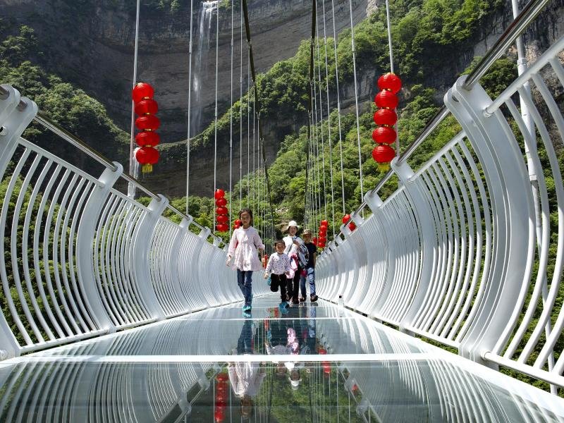 Touristen über eine Glasbrücke im Bezirk Zigui. Der Vorfall, bei dem ein Mann aus 100 Metern Höhe gerettet werden musste, heizt die Diskussion über die Sicherheit solcher Skywalks an.