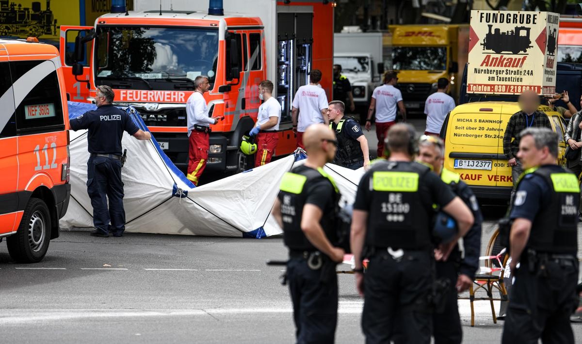 Einsatzkräfte und Polizei stehen nach einem Zwischenfall auf der abgesperrten Straße und sichern das Areal.