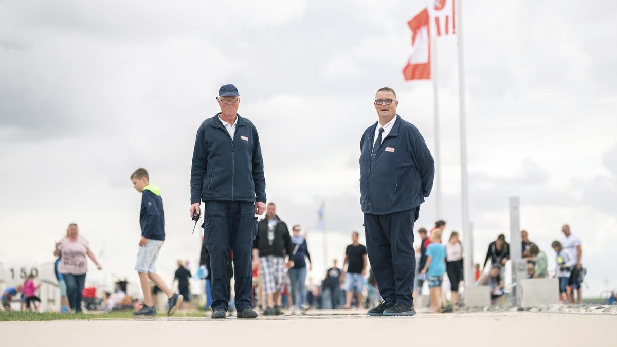 Georg Ulrichs (l) und Anton Siemers, beide Sicherheitskräfte der WSB-Sicherheitsdienst GmbH, stehen während ihres Kontrollrundgangs am Badestrand von Norddeich. 