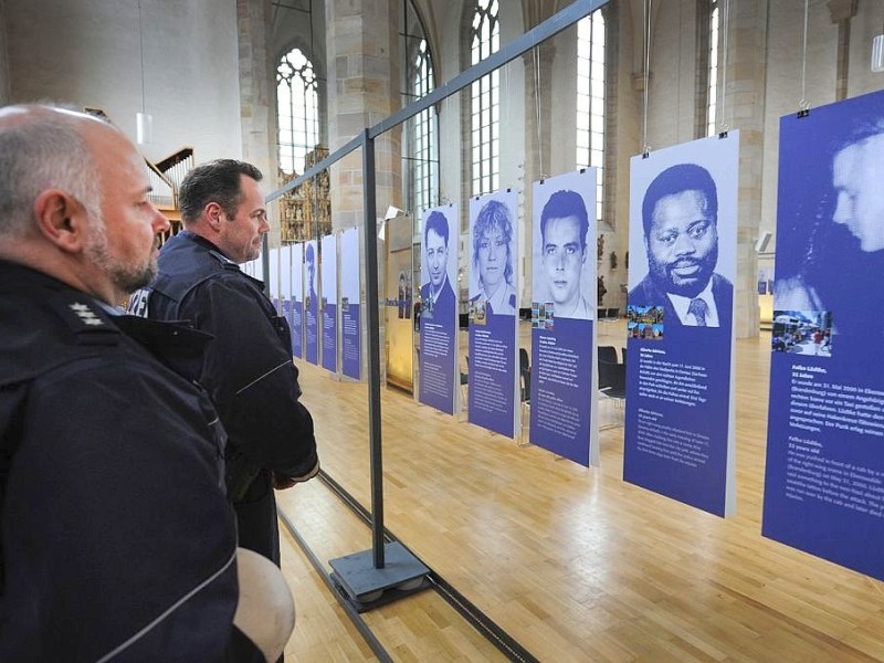 Die Polizisten Heiko Metzger und Michael Nockelmann  betrachten Bilder der Ausstellung.