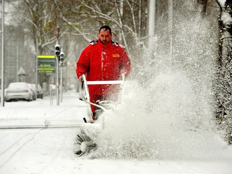 Uwe Posner befreit mit einem Schneepflug den Bürgersteig an der Düsseldorfer Strasse in Duisburg vom Schnee.