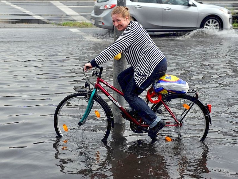 Eine Radfahrerin wartet sogar bei Starkregen auf Grün.Foto: Gerd Wallhorn / WAZ FotoPool