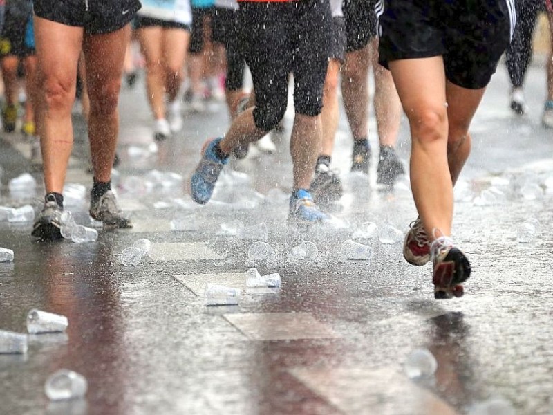 Teilnehmer des 22. Vattenfall-City-Nacht-Lauf passieren bei Temperaturen um 30 Grad Celsius auf dem Kurfürstendamm in Berlin eine Erfrischungsstation.