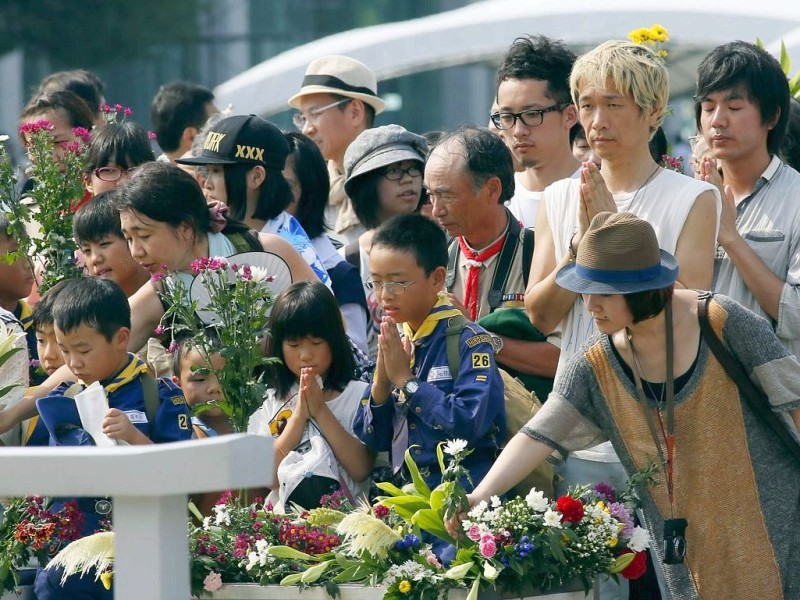 Viele Menschen gedenken  der Opfer des Atombombenabwurfs über Hiroshima vor 68 Jahren. Im Friedenspark steht noch immer eine Ruine als Mahnmal.