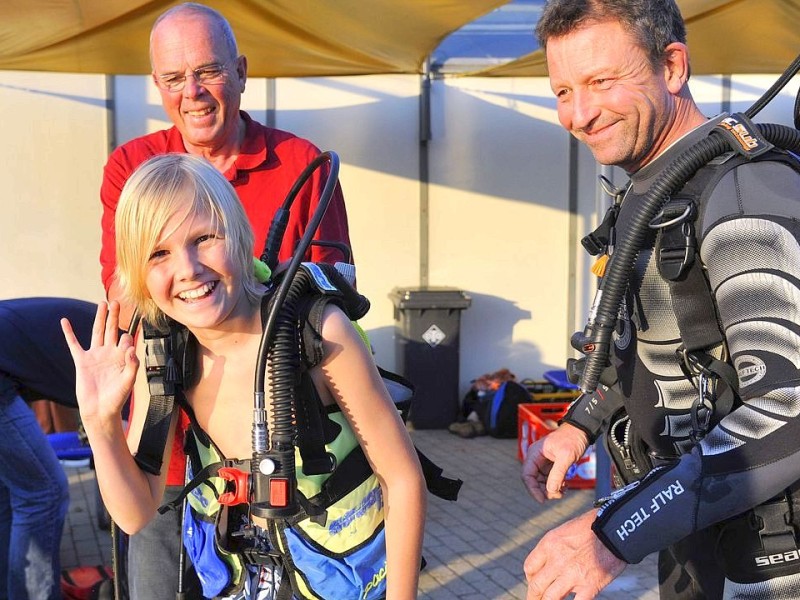 Schnuppertauchen für Kids bei den Tauchsportfreunden Herdecke im Freibad an der Hengsteyseestraße. Bild: Peter Granert (links) und Ernst Duhme (rechts) helfen Kevin (13, mitte) die schwere Ausrüstung für das Flaschentauchen anzulegen.Foto: Jürgen Theobald