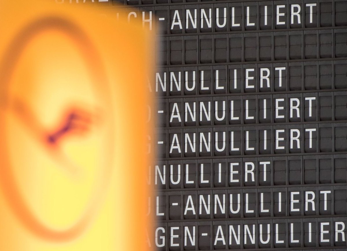Das Lufthansalogo vor einer Anzeigetafel