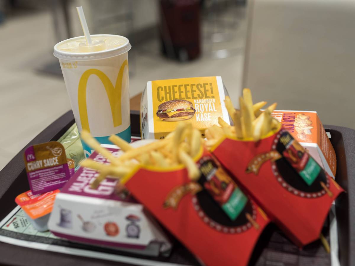 Auf einem McDonald's-Tablette stapeln sich Pommes, Burger und ein Getränk.