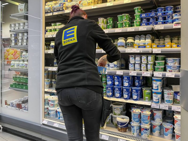 Bei Edeka räumt eine Mitarbeiterin die Regale ein.