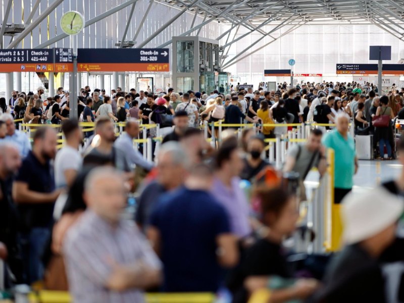 Am Flughafen drängen sich die Reisenden dicht an dicht.