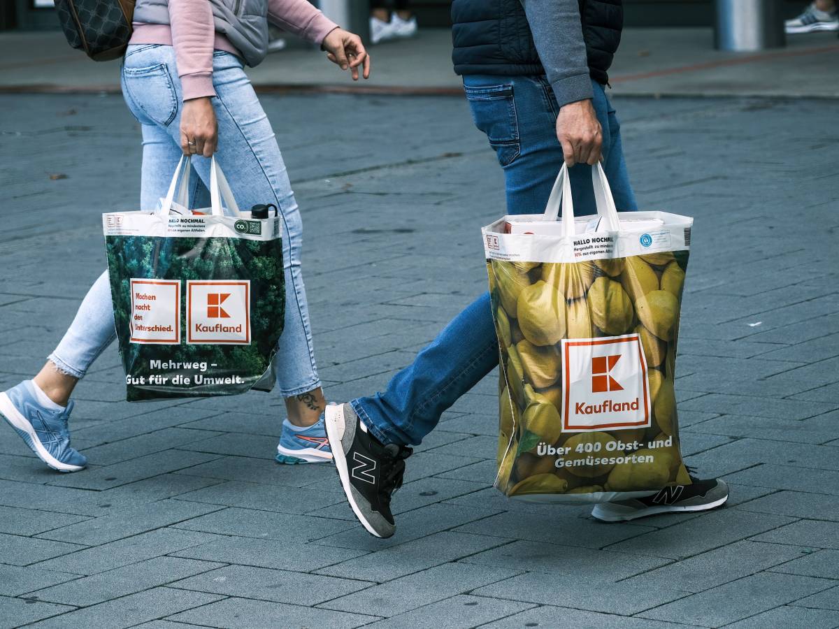 Zwei Menschen tragen ihre Einkäufe in Kaufland-Tüten.