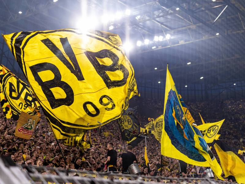 Fans von Borussia Dortmund schwenken Fahnen auf der Südtribüne.