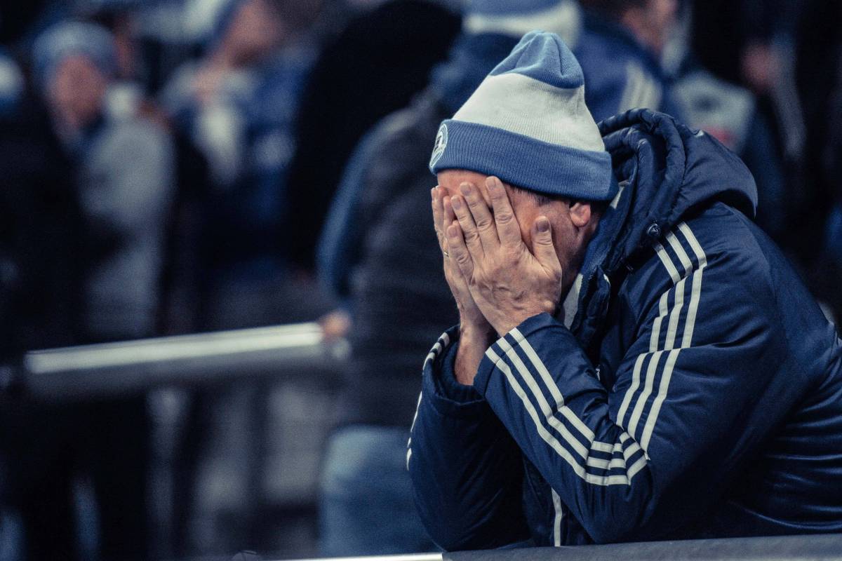 Ein Fan des FC Schalke 04 schlägt die Hände über dem Kopf zusammen.