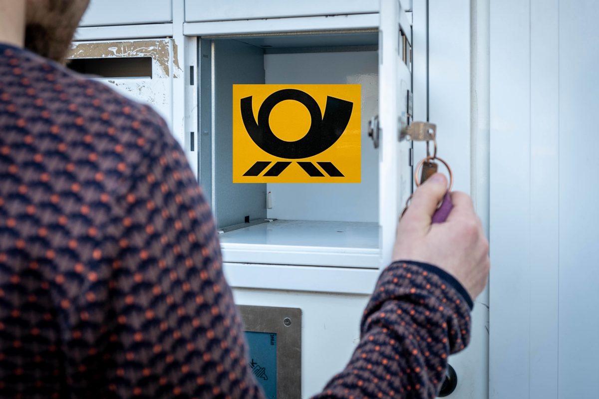Mann öffnet leeren Briefkasten mit Deutsche Post-Logo drin