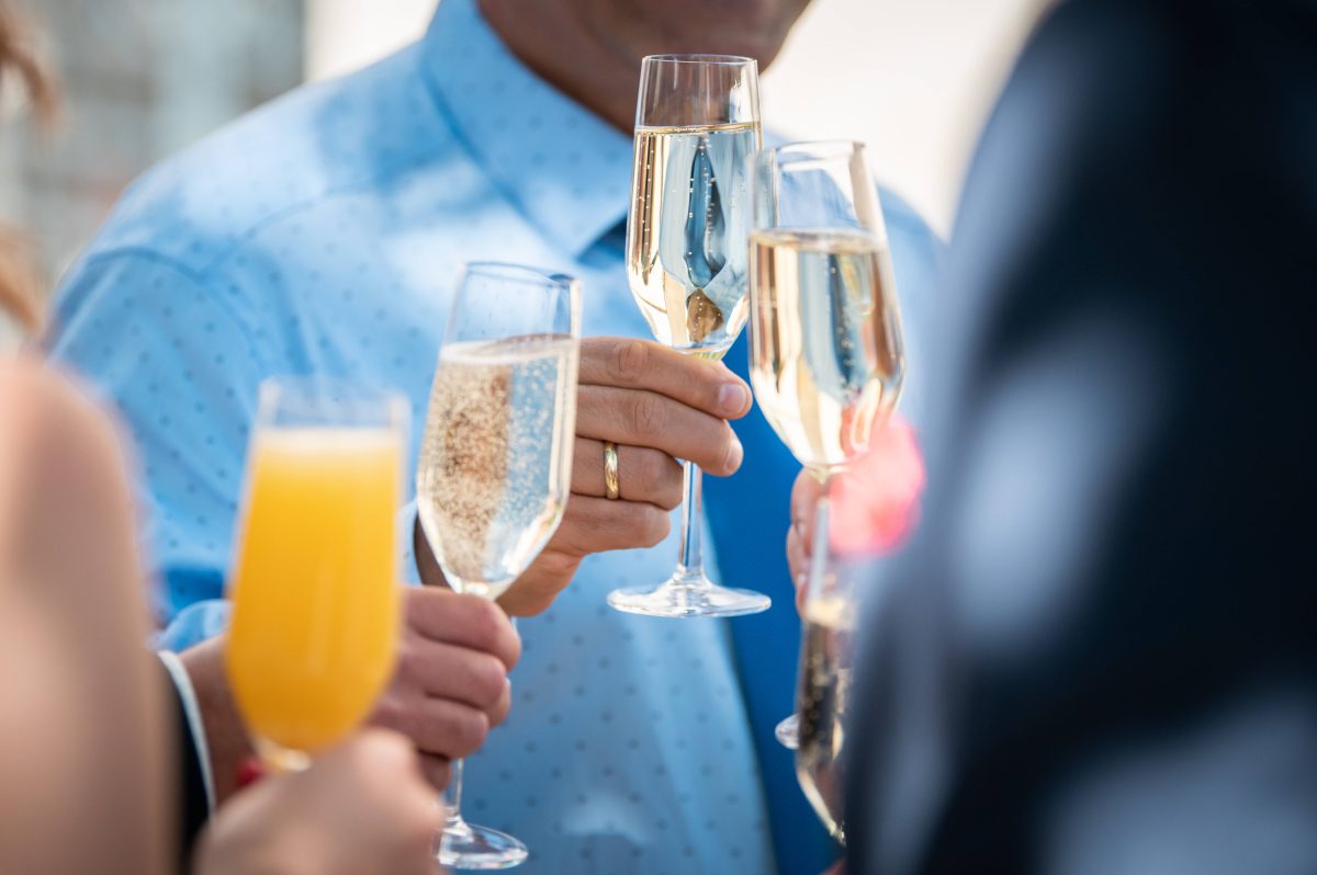 Hochzeitsgäste stoßen an mit Sekt und Orangensaft