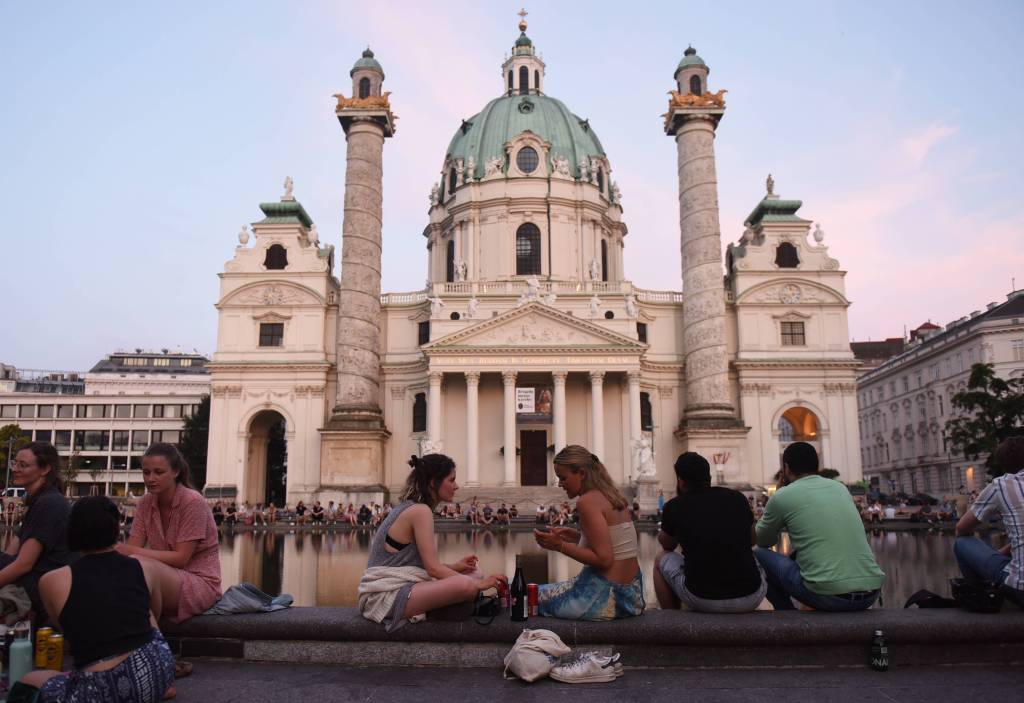 Junge Menschen sitzen vor einer Kirche in Österreich.