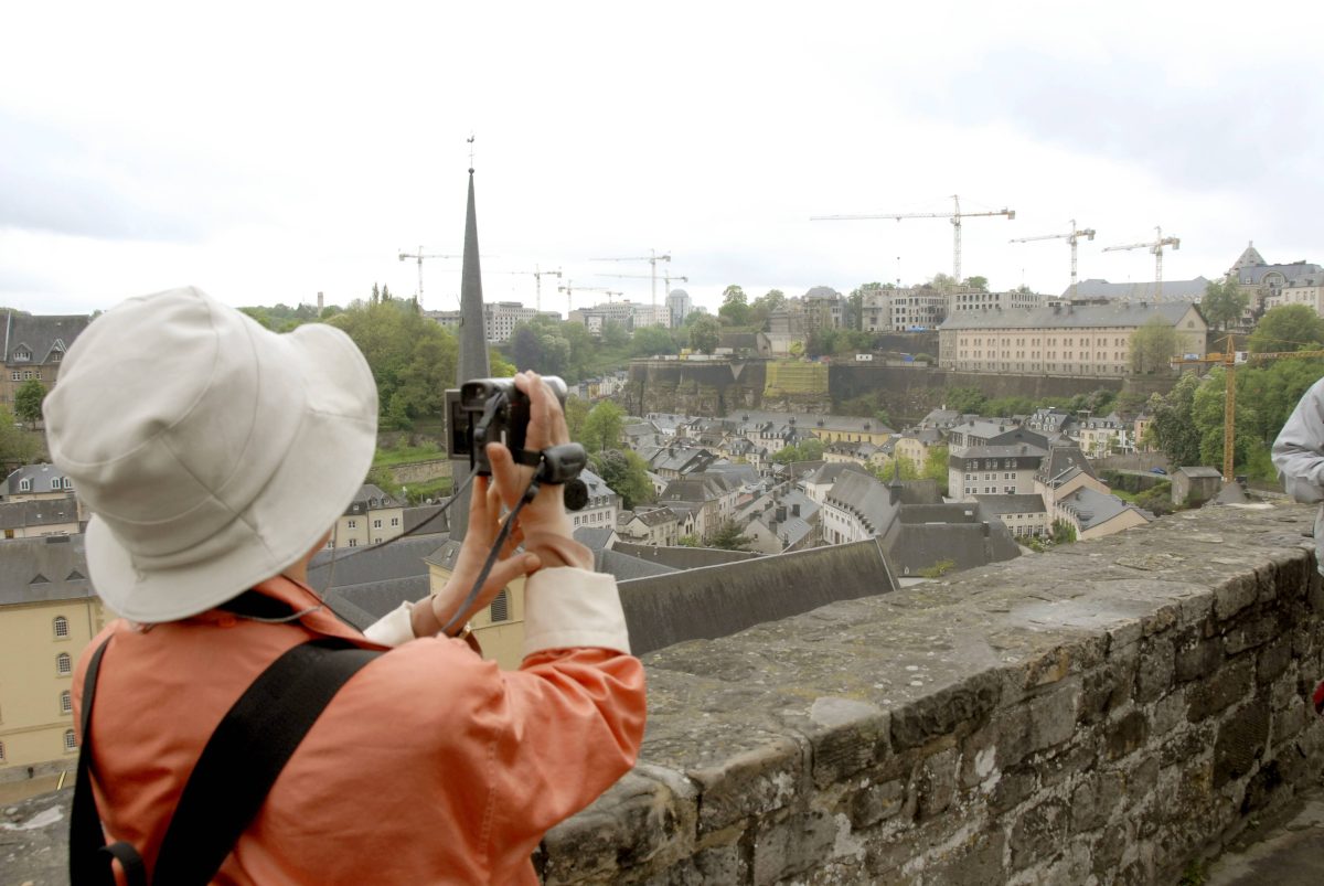 Eine Touristin filmt die historische Stadtmauer von Luxemburg.