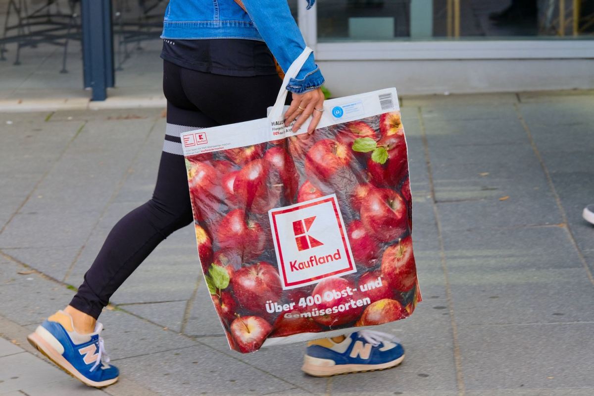 Ein Mensch trägt eine Einkaufstüte von Kaufland