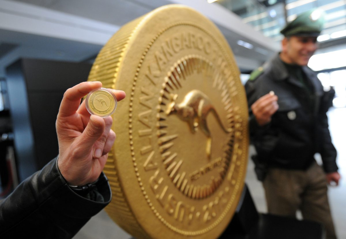Eine Polizistin hält eine 30 Gramm schwere Münze vor die wohl teuerste Münze der Welt, der Red-Kangaroo-Goldmünze.