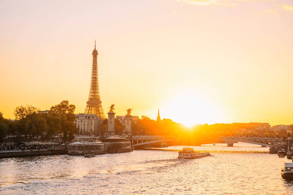 Der Fluss Seine mit dem Eiffelturm im Hintergrund bei Sonnenuntergang.