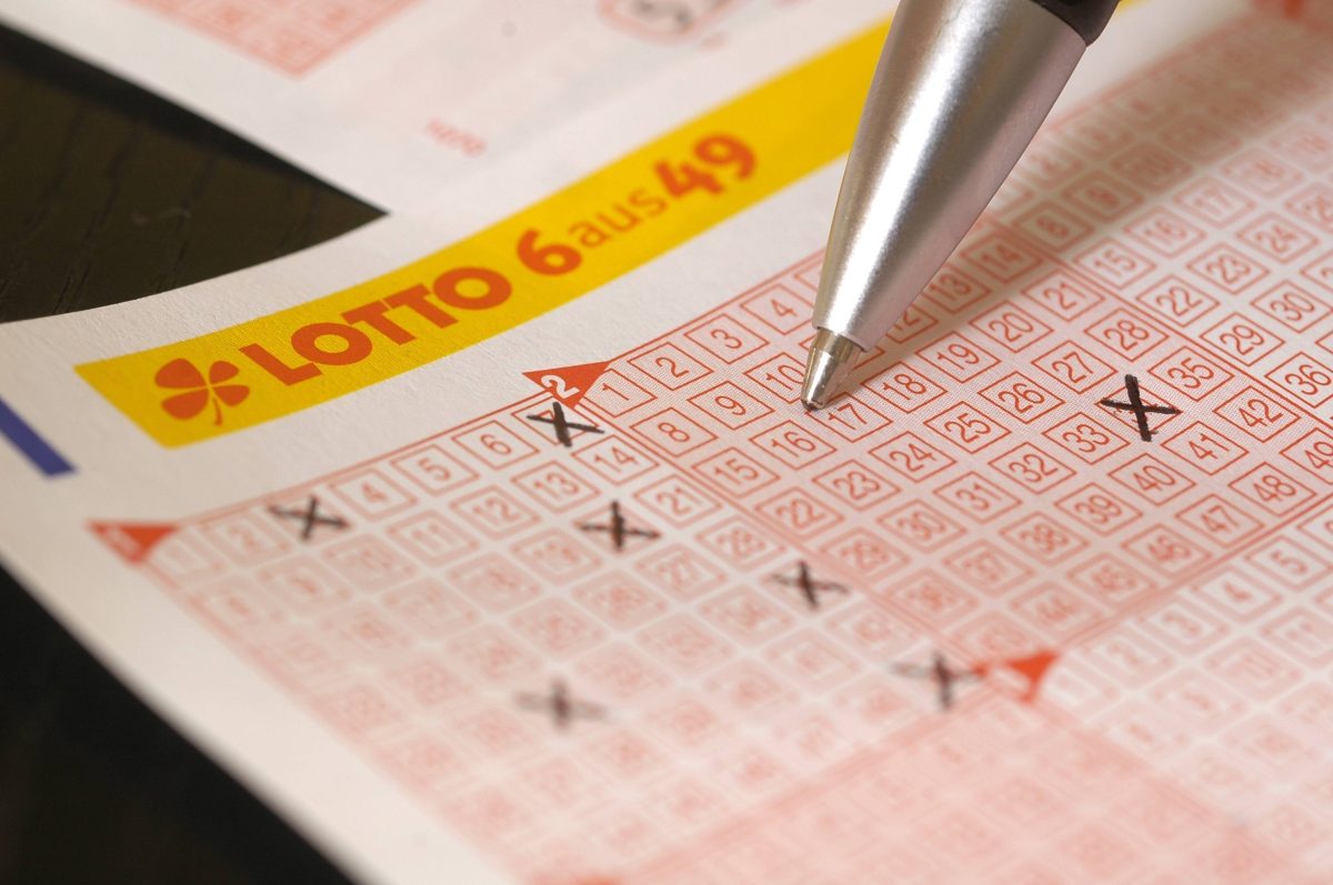 Ein Spieler kreuzt Zahlenfelder auf einem Lotto-Tippschein der Variante "6 aus 49" an.