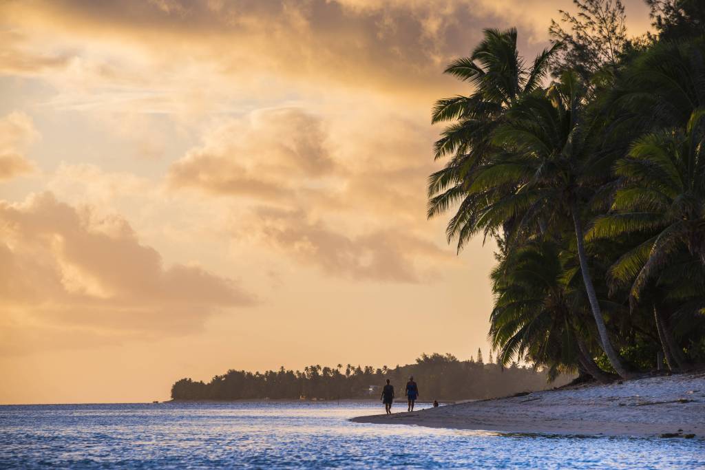 Paar am tropischen Strand bei Sonnenuntergang.