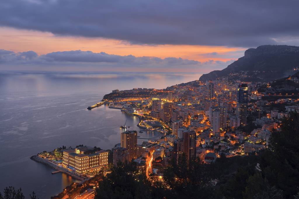 Die beleuchtete Skyline der Häfen von Monaco bei Sonnenuntergang.