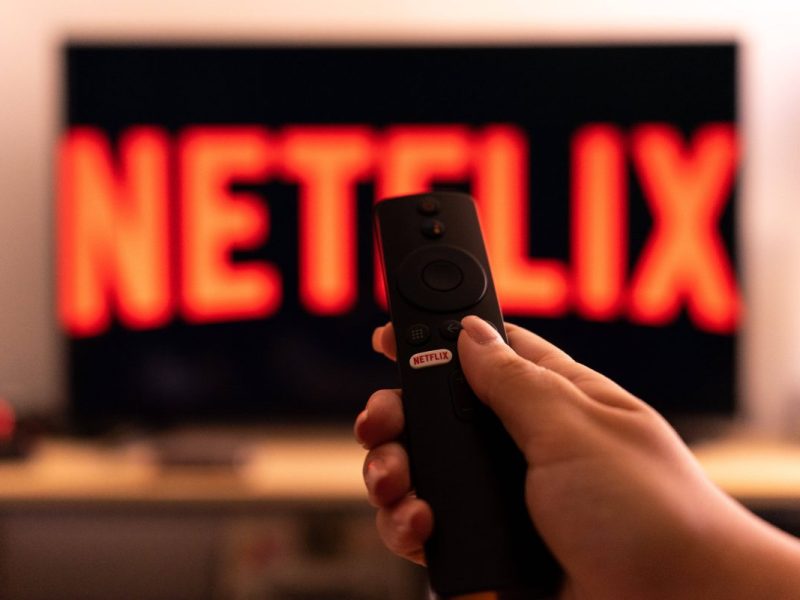 Fernbedienung vor Fernseher mit Netflix-Logo