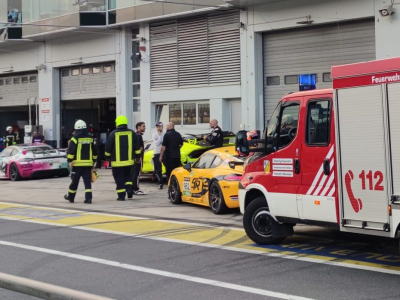 Nürburgring: Feuerwehrleute laufen vor Box 27 in der Boxengasse. Bei der Explosion einer Druckluftflasche hinter der Box im Bereich des Fahrerlagers wurden etliche Menschen verletzt.